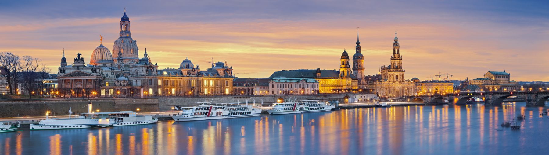 Panoramic image of Dresden, Germany during sunset with Elbe River in the foreground. This is composite of two horizontal images stitched together in photoshop.